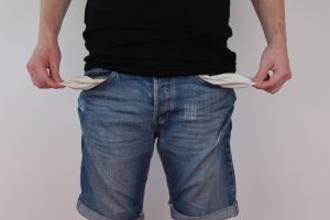 Man holding out empty pockets, signifying that he is broke and has no money. Left to continue, this man will have no retirement savings. Credit: Pixabay