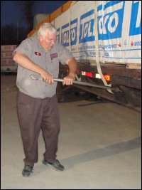 Mike Simons using a 'buck bar' to tighten a strap on a flatbed load he was preparing to deliver to a customer.