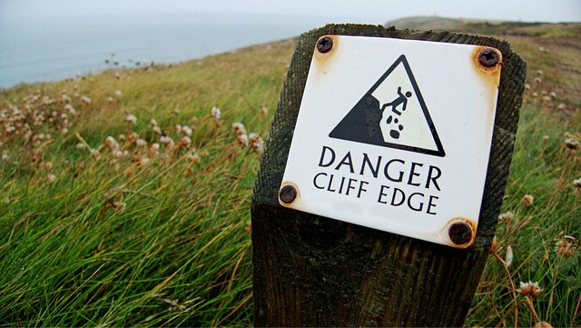 A 'DANGER CLIFF EDGE' sign is similar to economic vulnerability in a person's life.