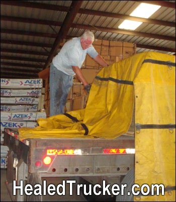 Mike Simons tarping a load on a flatbed trailer that he was preparing to haul as a full-time professional truck driver. Healed Trucker, HealedTrucker.com.